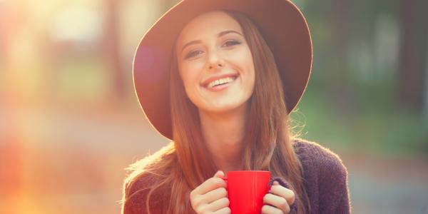Vrou lachend kijkend met kopje koffie